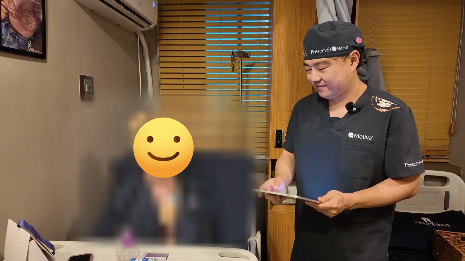 Surgeon reviewing before photos with the patient at the final check after breast implant revision